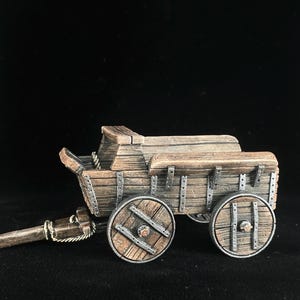May include: A miniature wooden wagon with two spoked wheels. The wagon is painted in shades of brown and gray, with a weathered appearance. The wagon has a long wooden tongue and is designed to be pulled.