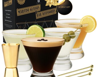 May include: A martini glass and bar accessories gift set. The set includes martini glasses, a gold-colored jigger, and cocktail picks. The glasses are filled with cocktails and garnished with olives, lime, and lemon slices. The box reads "MARTINI GLASSES & BAR ACCESSORIES".
