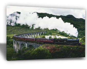 May include: A red and black steam train travels across a stone bridge with a large plume of white smoke trailing behind it. The train is travelling through a lush green valley with mountains in the background.