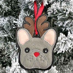 May include: Gray felt Christmas ornament shaped like a French bulldog with brown antlers and a red nose.