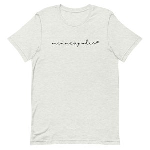 May include: A heather grey t-shirt with the word "minneapolis" written in black cursive script.