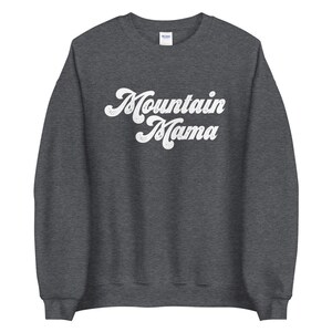 May include: A dark grey sweatshirt with the text "Mountain Mama" in a white retro font.