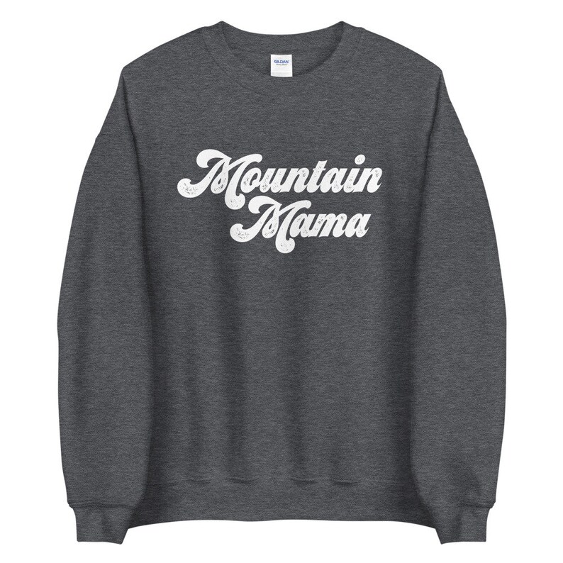May include: A dark grey sweatshirt with the text "Mountain Mama" in a white retro font.