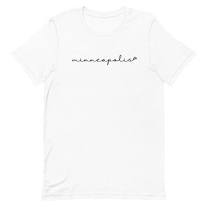 May include: White t-shirt with the word "minneapolis" written in black cursive script.