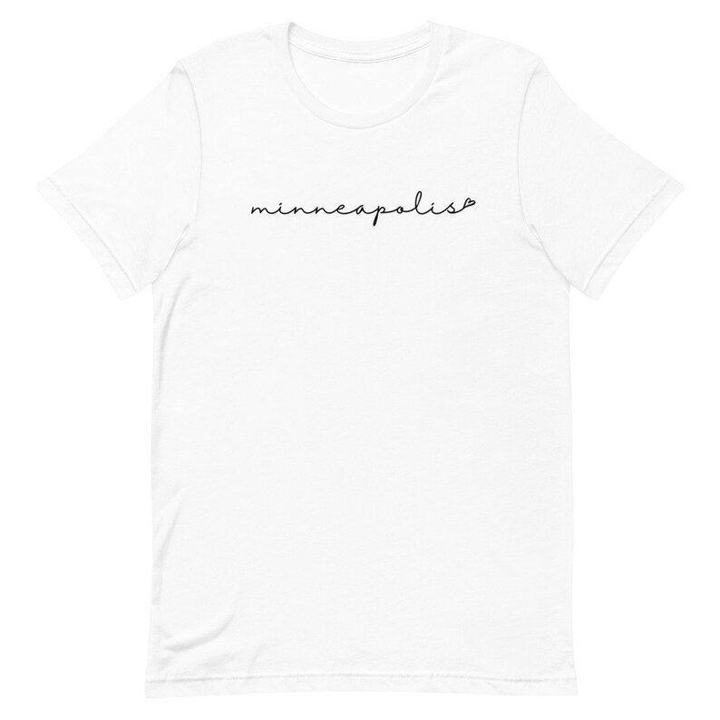 May include: White t-shirt with the word "minneapolis" written in black cursive script.