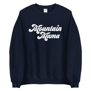 May include: A navy blue sweatshirt with the text "Mountain Mama" in white retro-style lettering.
