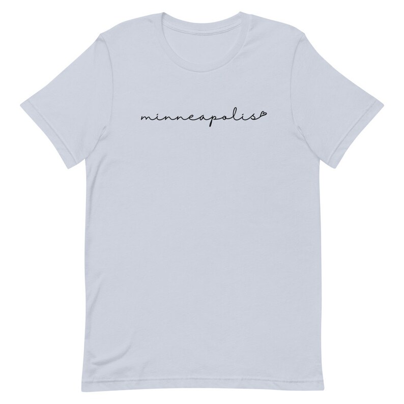 May include: Light blue t-shirt with the word "minneapolis" written in black cursive script.