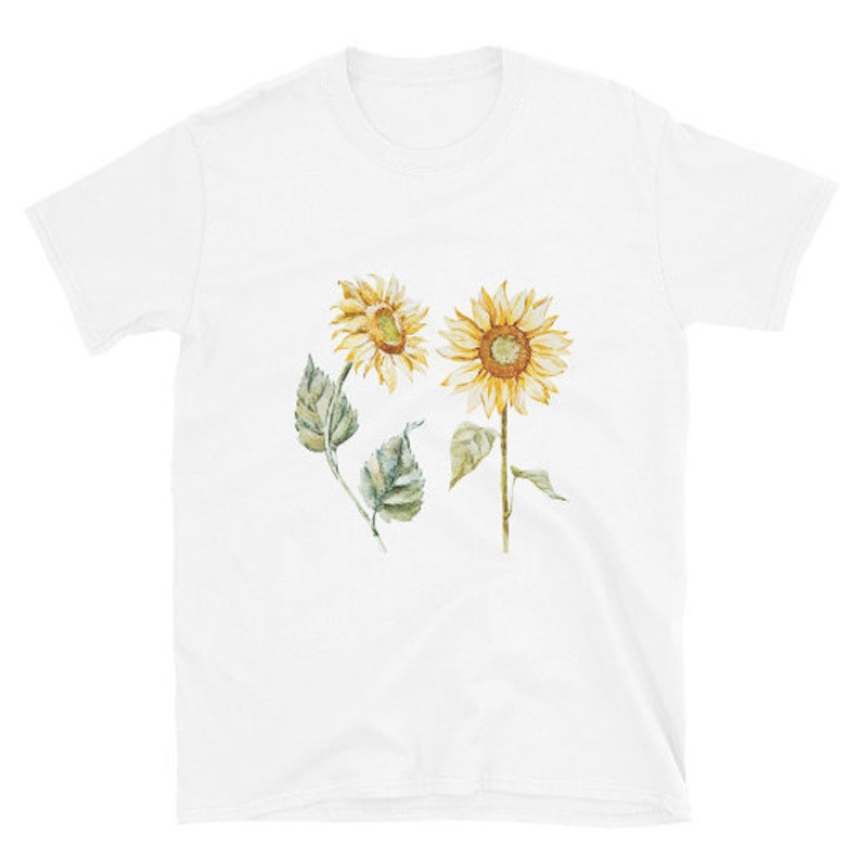 May include: White t-shirt with a watercolor illustration of two sunflowers with green leaves.