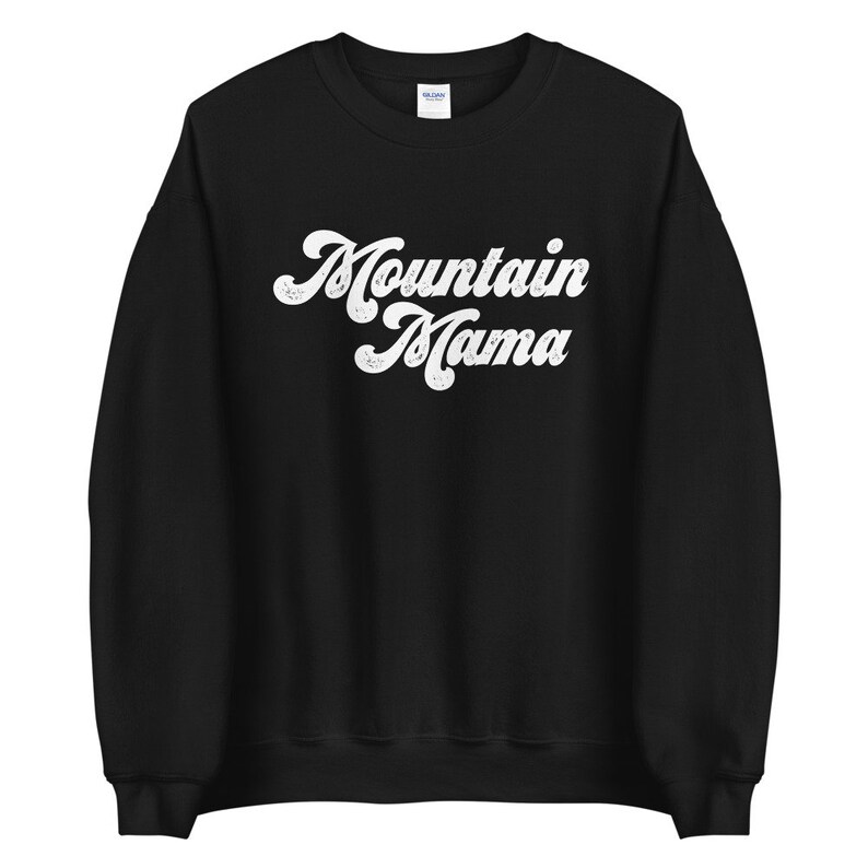 May include: Black sweatshirt with white text that reads "Mountain Mama" in a retro font.