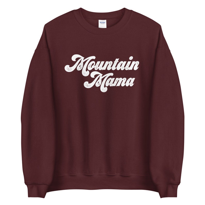 May include: A maroon sweatshirt with the text "Mountain Mama" in white retro-style lettering.