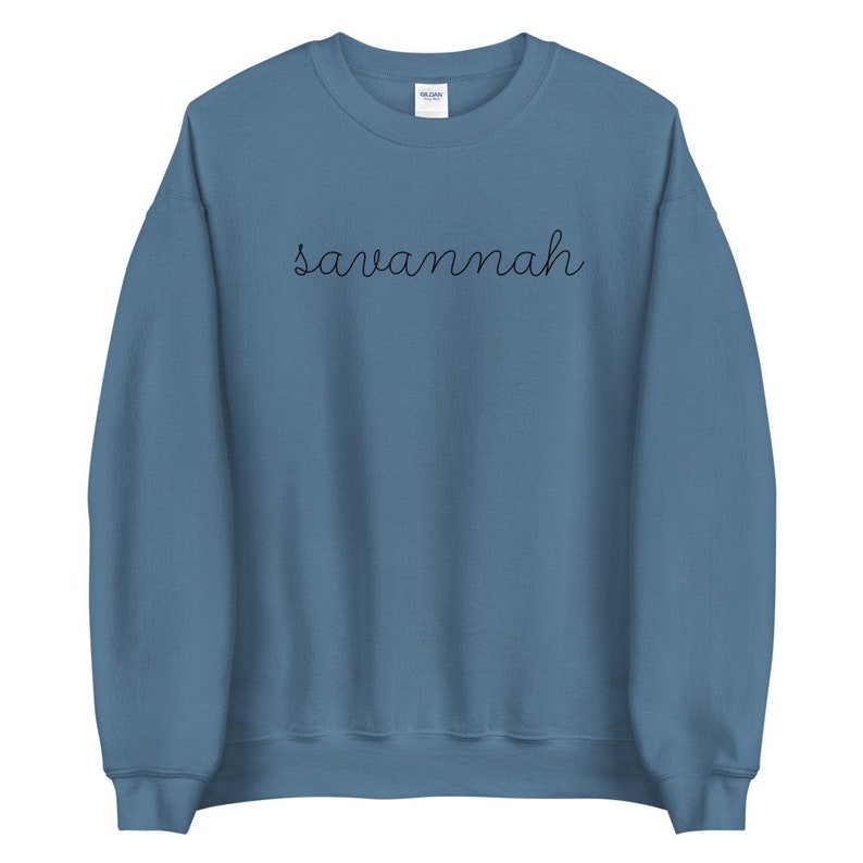 May include: A blue sweatshirt with the word "Savannah" written in black cursive on the front.