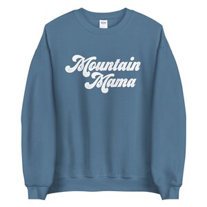 May include: A blue sweatshirt with the text "Mountain Mama" in a white retro font.