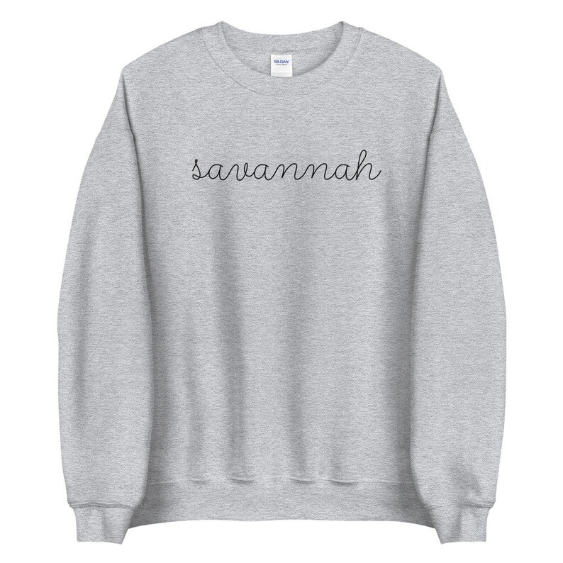 May include: A gray sweatshirt with the word "savannah" written in black cursive on the front.