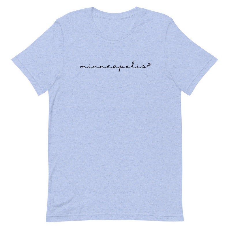 May include: Light blue t-shirt with the text "minneapolis" in black cursive writing.