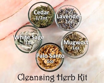 May include: A cleansing herb kit with five glass bowls containing dried herbs and wood chips. The bowls are arranged in a circle on a pink and white marble surface. The herbs include white sage, cedar, lavender, mugwort, and palo santo. The text on the bowls reads "White Sage 1oz", "Cedar 1/2oz", "Lavender 1oz", "Mugwort 1oz", and "Palo Santo 1oz". The text "Cleansing Herb Kit" is written below the bowls.