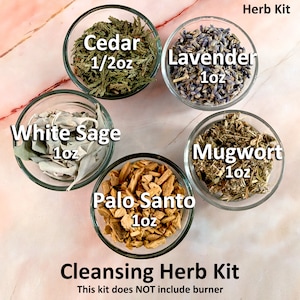 May include: A cleansing herb kit with five glass bowls containing dried herbs. The bowls are labelled with the names of the herbs: Cedar (1/2 oz), Lavender (1 oz), White Sage (1 oz), Mugwort (1 oz), and Palo Santo (1 oz). The text "Cleansing Herb Kit" and "This kit does NOT include burner" is printed below the bowls.