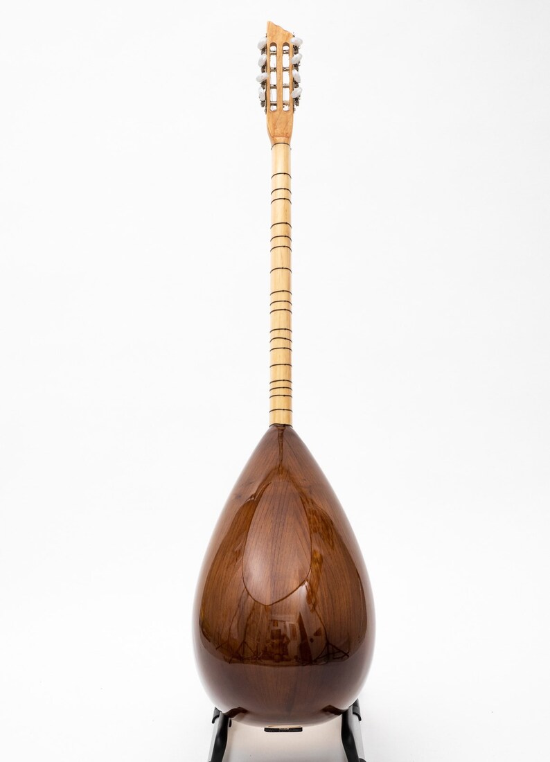 May include: A brown wooden saz, a Turkish stringed instrument, with a pear-shaped body and a long neck with tuning pegs at the top.