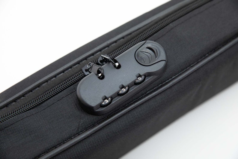 Puede incluir: Una maleta de viaje negra con cremallera y una cerradura de combinaci&oacute;n. La cerradura tiene tres diales con n&uacute;meros del 0 al 9.