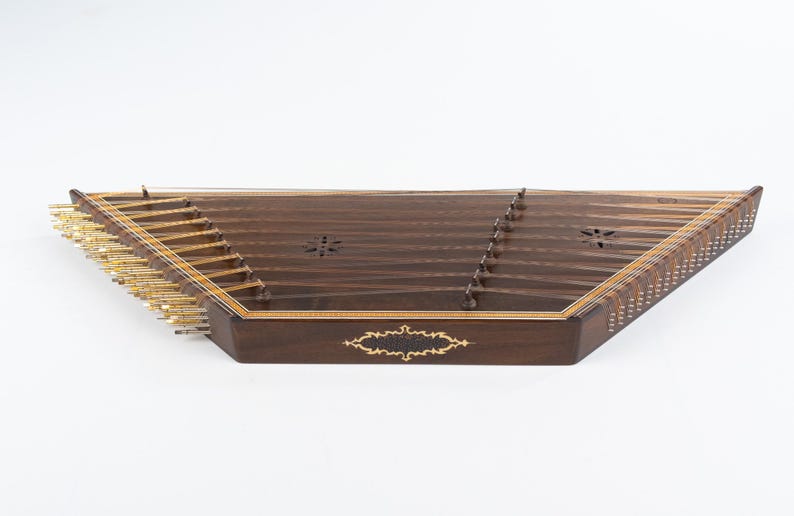 May include: A dark brown wooden santur, a hammered dulcimer, with gold tuning pegs and intricate inlaid designs.