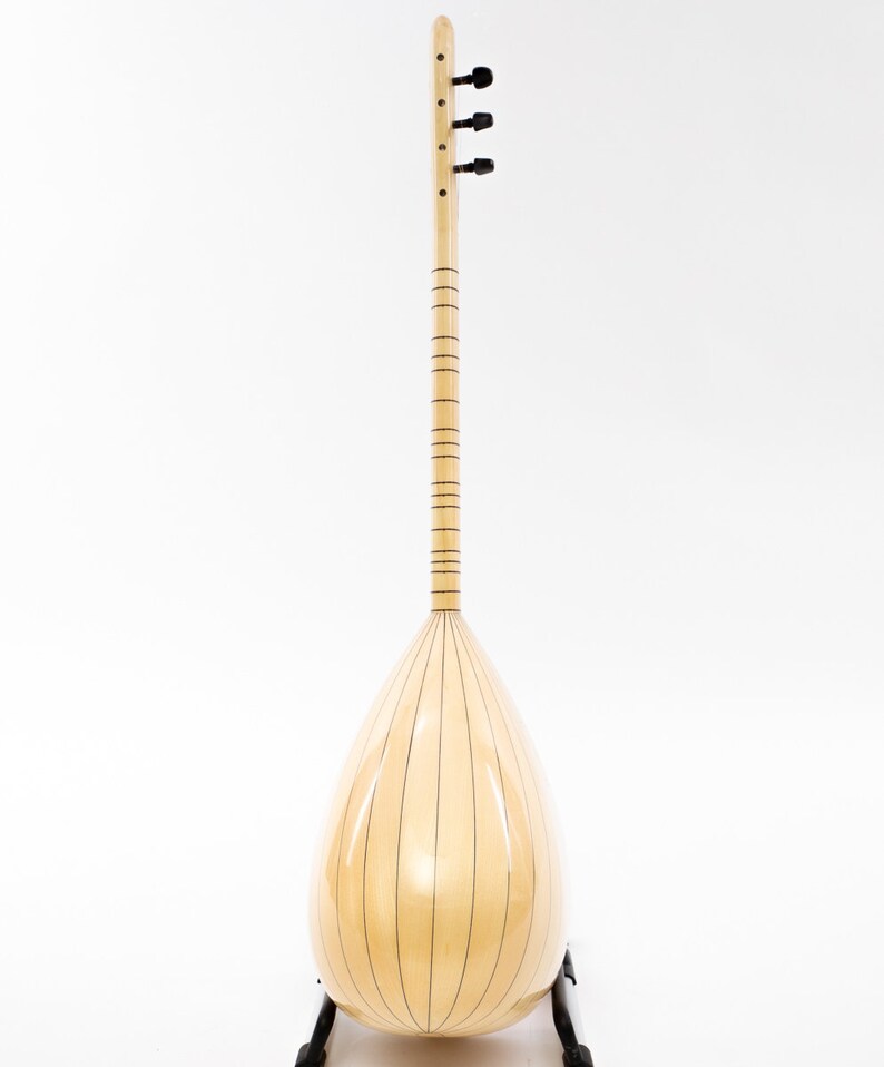 May include: A light wood  saz, a traditional Turkish stringed instrument, with a pear-shaped body and a long neck. The saz is on a black stand and has a natural wood finish.