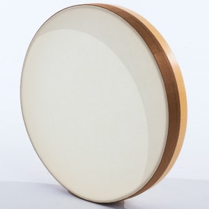 May include: A round, wooden frame drum with a white, leather head and a brown, fabric trim around the edge.