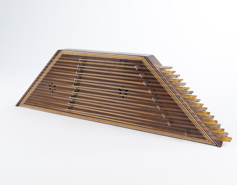May include: A wooden santur, a trapezoidal hammered dulcimer with a dark brown wood finish and intricate inlaid designs. The instrument has 10 strings and a set of metal tines on the right side.