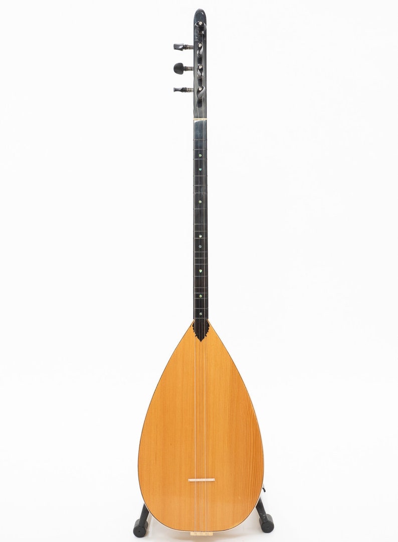 May include: A traditional Turkish stringed instrument called a Saz. The Saz has a pear-shaped body, a long neck with tuning pegs, and a wooden soundboard.
