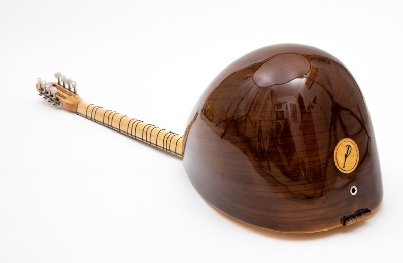 May include: A brown wooden  saz, a Turkish stringed instrument, with a round body and a long neck. The saz has a  P sticker on the body.