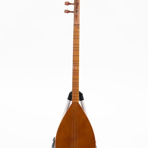 May include: A wooden stringed instrument, likely a saz or similar folk lute, with a pear-shaped body and a long neck. The instrument is a warm brown color and is supported by a silver and black stand. The headstock features tuning pegs.