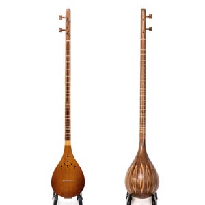Puede incluir: Dos vistas de un instrumento musical de cuerda de madera con un mástil largo y un cuerpo en forma de pera. La vista frontal muestra una caja de resonancia con pequeños orificios acústicos, mientras que la trasera muestra vetas.