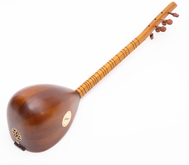 May include: A wooden stringed instrument with a pear-shaped body and a long neck. The instrument is a warm brown color with a lighter-colored neck and tuning pegs. The sound hole is decorated with a circular pattern.