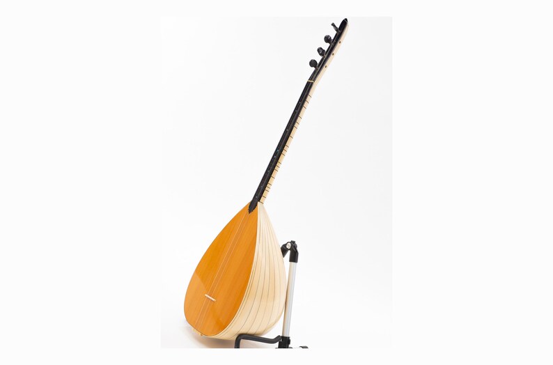 May include: A traditional Turkish stringed instrument called a saz, with a pear-shaped body and a long neck with tuning pegs. The saz is made of wood and has a natural finish.