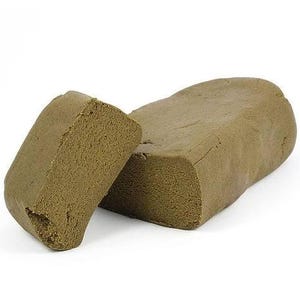 May include: Two rectangular blocks of a brownish-green substance are displayed against a white background. One block is partially separated, revealing a porous texture. The other block is intact, showing a smooth surface with slight imperfections.