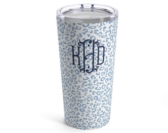 May include: A white stainless steel tumbler with a blue leopard print design and the monogram "KHD" in navy blue.