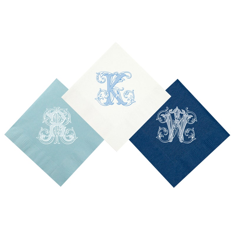 May include: Three folded napkins with different colored backgrounds and white embroidered monograms. The napkins are light blue, white, and dark blue. The monograms are "A", "K", and "W".