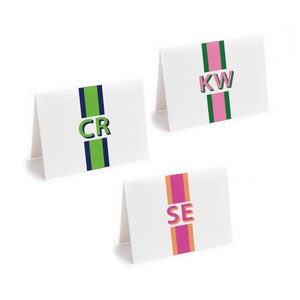 May include: Three white cards with green, pink, and orange stripes and navy blue stripes. The cards have the letters "CR", "KW", and "SE" in a bold, 3D-style font.