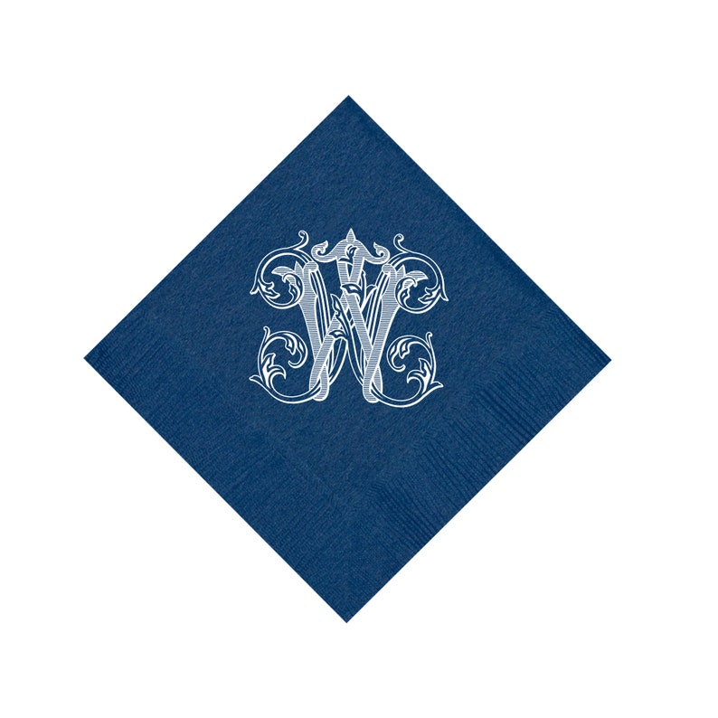 May include: A dark blue square napkin with a white monogram of the letter "W" in a decorative, ornate font.