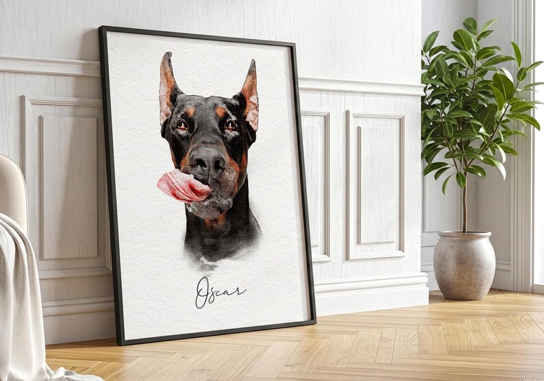 May include: A framed wall art print featuring a watercolor-style portrait of a black and tan Doberman Pinscher dog with its tongue out, positioned above the name Oscar written in a black cursive script on a textured white background.