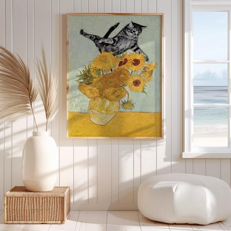 Puede incluir: Una pintura de un gato saltando sobre un jarr&oacute;n de girasoles. El gato es gris y blanco y los girasoles son amarillos con centros marrones. La pintura est&aacute; en un marco azul claro.
