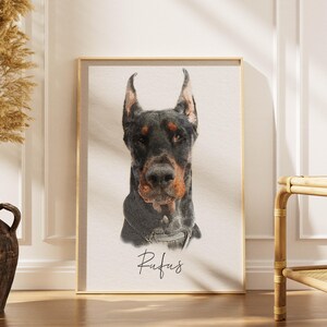 May include: A rectangular framed print featuring a detailed portrait of a black and tan Doberman dog with pointed ears. The dog is wearing a collar, and the name Rufus is written in a cursive black script font centered below the animal portrait.