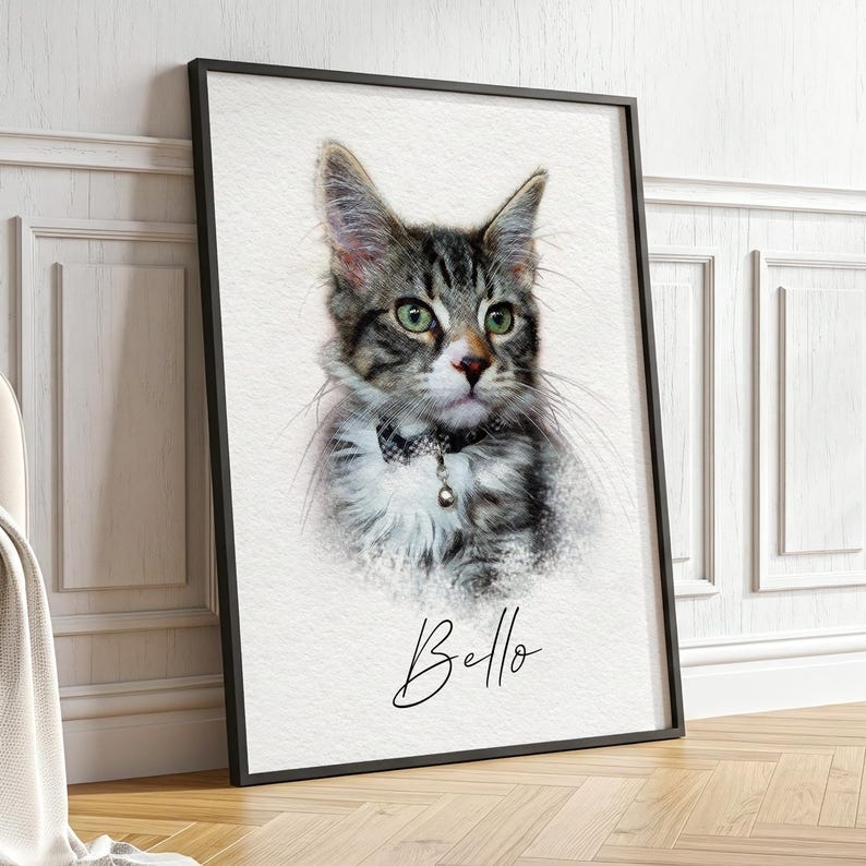 May include: A framed wall art print featuring a digital illustration of a tabby cat with green eyes and a small collar with a bell. The cat is depicted against a white background with the name Bello written in black cursive script below it.