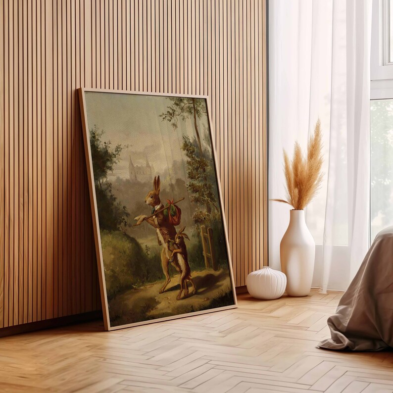 May include: A vintage painting of two rabbits in a forest setting. The rabbit on the left is wearing a bow tie and carrying a small bag. The rabbit on the right is following behind. The painting is framed in a light wood frame.