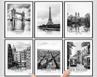 May include: A set of six black and white framed wall art prints featuring cityscapes of London, Paris, Central Park, Amsterdam, Barcelona, and New Orleans. Each print includes the city name, country, and geographic coordinates in white text.