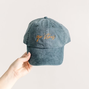 May include: A dark blue baseball cap with the text "go stros" embroidered in orange.