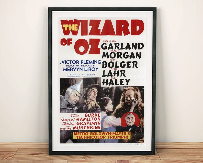 May include: A vintage movie poster for the film "The Wizard of Oz" featuring Judy Garland, Ray Bolger, Jack Haley, and Bert Lahr. The poster is in black and white with a red and yellow title and features a scene from the film with Dorothy, the Tin Man, the Scarecrow, and the Cowardly Lion.