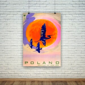 Puede incluir: Un cartel de viaje vintage para Polonia con un sol naranja brillante y un cielo rosa y morado. Tres pájaros azules vuelan frente al sol. El texto dice "POLAND - where you can really relax".
