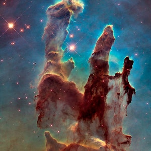 May include: A vibrant nebula with tall, red, and orange pillars of gas and dust, illuminated by bright blue and white stars. The background is a dark blue with scattered stars.