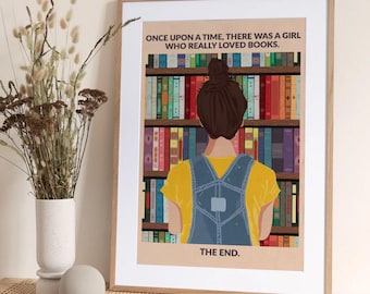 Könnte beinhalten: Ein gerahmter Kunstdruck mit einem Mädchen vor einem Bücherregal. Das Mädchen trägt ein gelbes T-Shirt und eine Jeans-Latzhose. Der Text lautet: „ES WAR EINMAL EIN MÄDCHEN, DAS BÜCHER WIRKLICH LIEBTE. ENDE.“