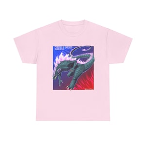 Puede incluir: Camiseta rosa con un estampado gráfico de un monstruo Godzilla verde con cristales rosas en la espalda. El texto "Godzilla Evolved" está por encima del monstruo. El texto "@roundtran" está por debajo del monstruo.