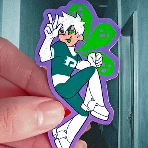 May include: A sticker featuring a cartoon character in a green and white outfit with a purple outline. The character has white hair, green eyes, and is making a peace sign with one hand. A green ghost-like shape is behind the character.